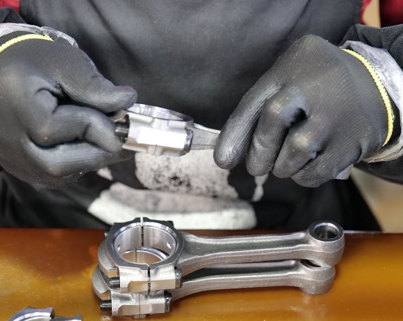 a car technician checking and assembling connecting rod